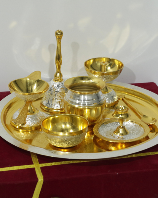 Set of gold and silver ceremonial items on a red and gold tray.