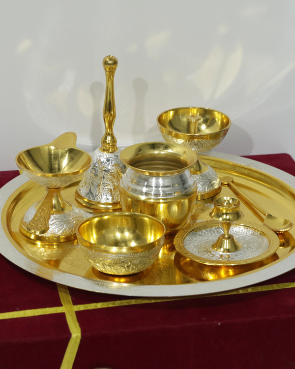 Set of gold and silver ceremonial items on a red and gold tray.